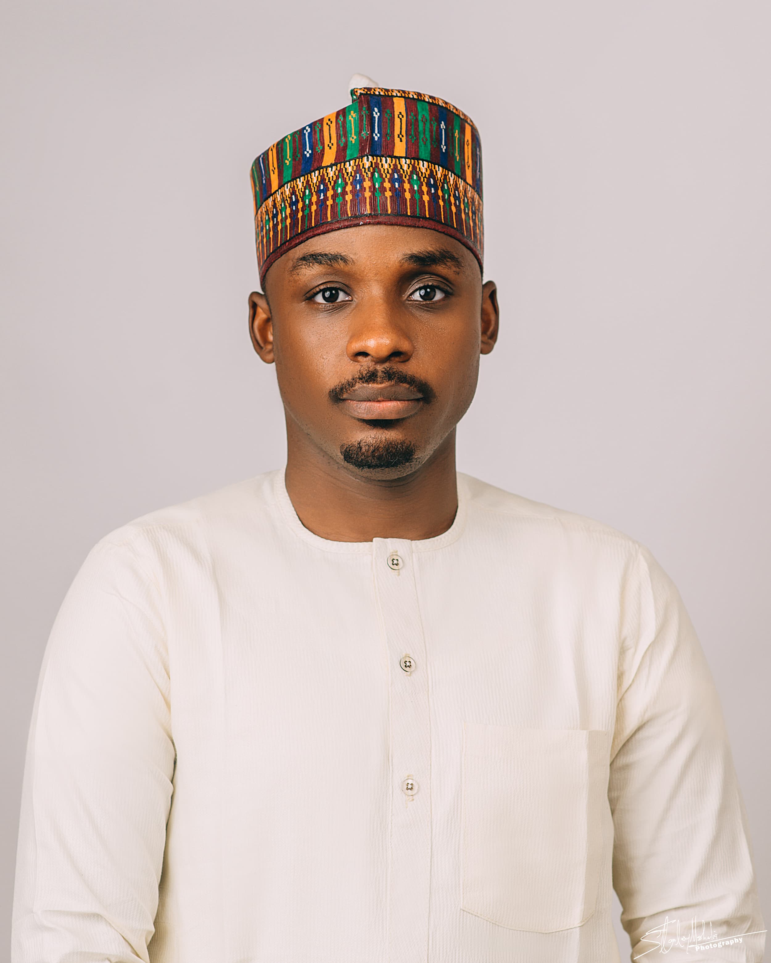 Portrait of Ibrahim Muhammad Saghir, Co-Founder and COO of SiyaExpress Ltd, wearing a cream kaftan and a patterned cap