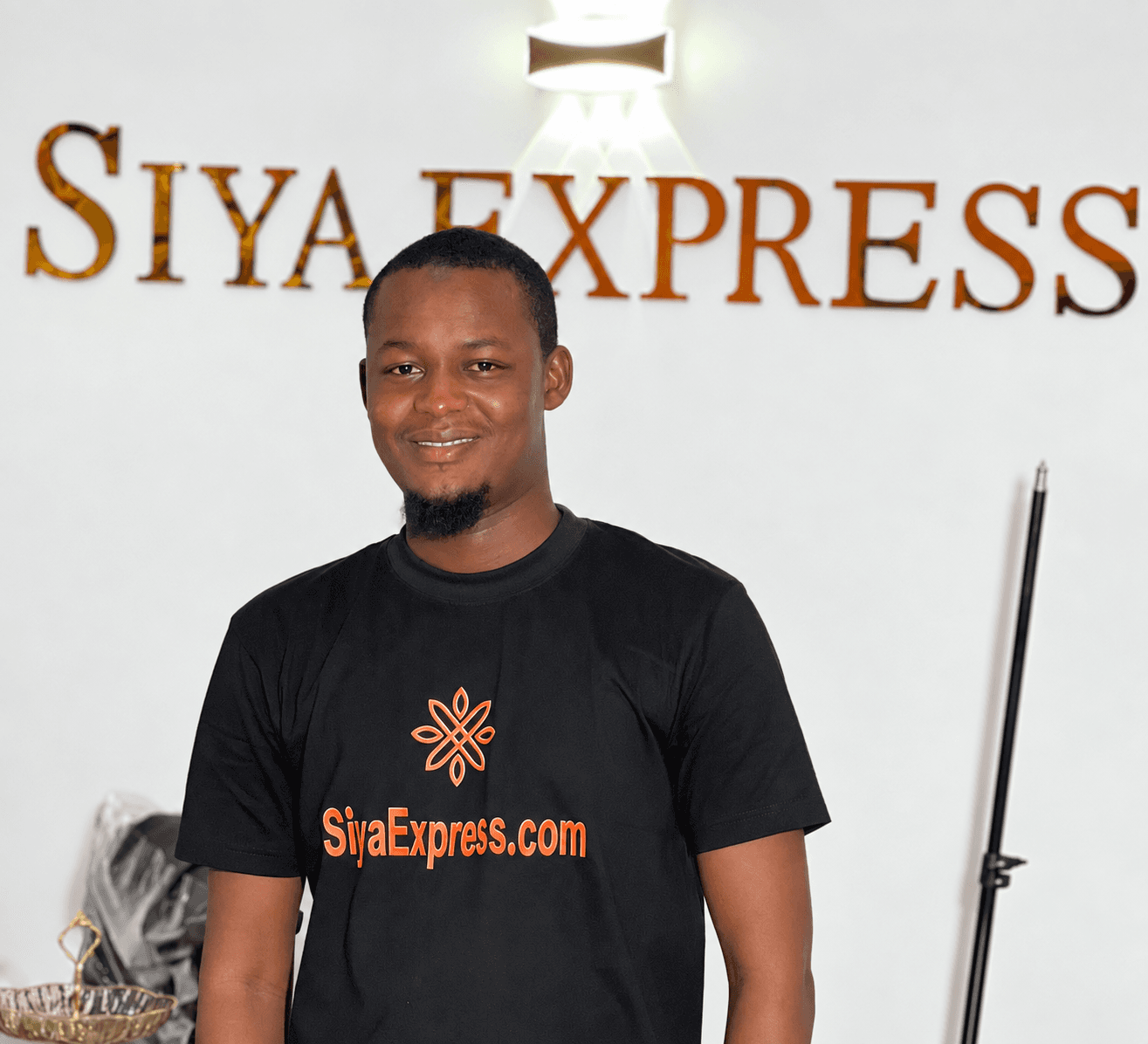 Portrait of Sadiq Bukar Mustapha, Founder and CEO of SiyaExpress Ltd, smiling in a black SiyaExpress.com T-shirt